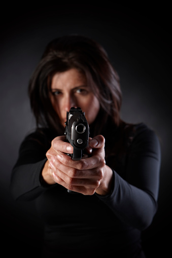 Women with a gun taking aim.
