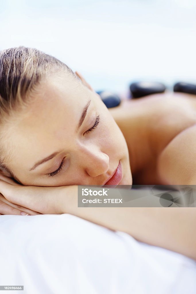 Jovem mulher ficando de uma massagem com pedras no spa - Foto de stock de 18-19 Anos royalty-free