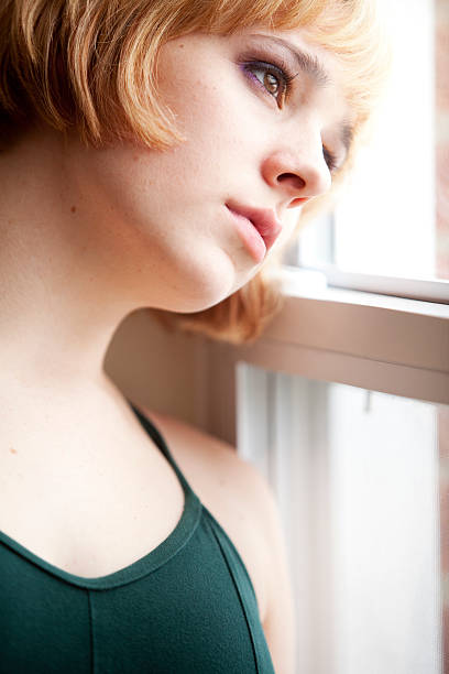 istock Sad Young Woman Looks out Window 182496685