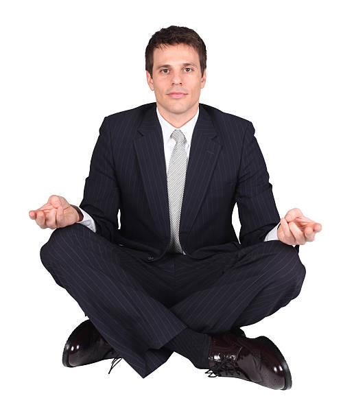 istock Isolated businessman sitting legs crossed meditating 182497419