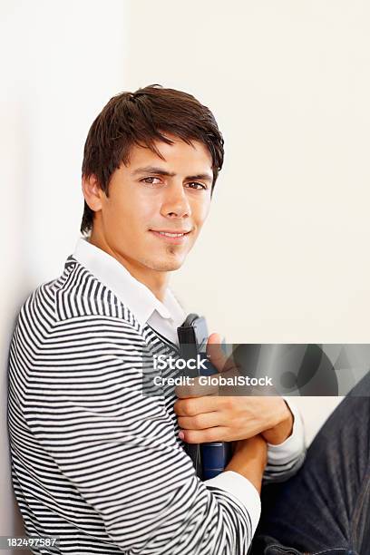 College Student Holding Books Leaning Against A Wall Stock Photo - Download Image Now