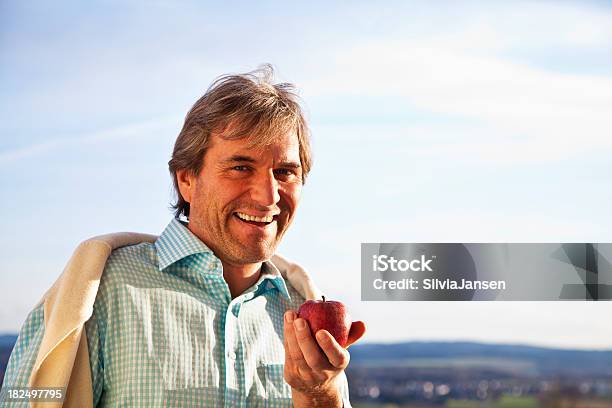 Maduro Hombre Comiendo Una Manzana Foto de stock y más banco de imágenes de 45-49 años - 45-49 años, Actitud, Adulto