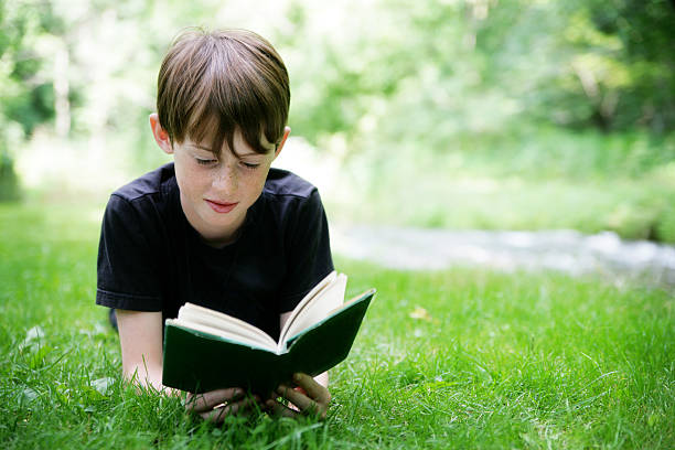 istock Happy Child Reading A Book Outside in Nature 182498125