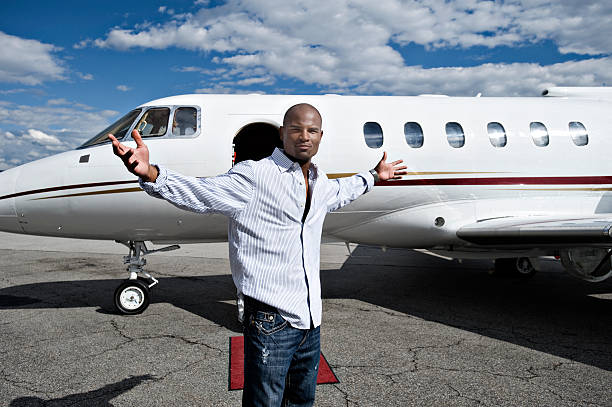 A tourist stands with her hands on hips next to her small plane.