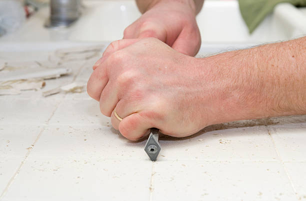 Male hand removing grout from kitchen tiles A man chisels grout from kitchen countertop. : Click : for more in this series chisel photos stock pictures, royalty-free photos & images