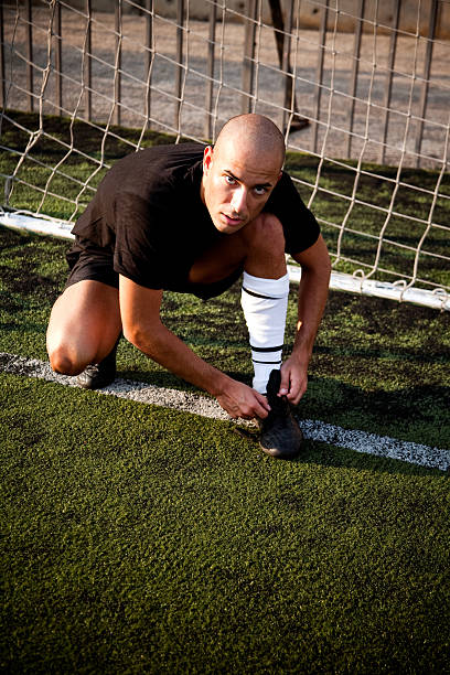 istock Soccer Player Tying His Shoe at the Goal 182498431