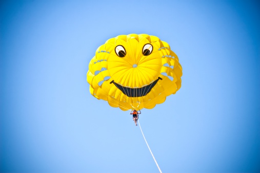 Parasailing. Girl under a canopy. Yellow parachute. Summer resort entertainment.