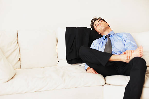 istock Young business man sleeping on couch at home 182498457