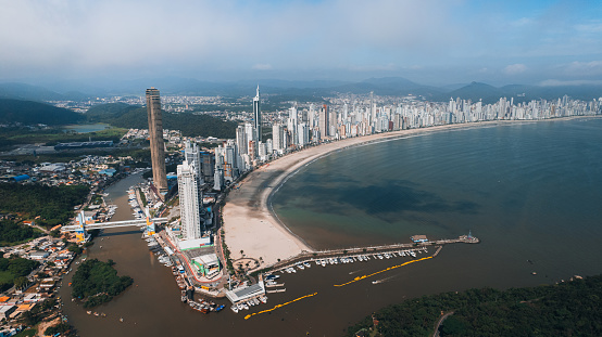 Aerial photo of the beachfront of Balneário Camboriú, on the coast of Santa Catarina, southern Brazil, with very tall buildings, wide strip of sand, blue sea, speedboats, luxurious city, tourist attractions, largest building in Latin America
