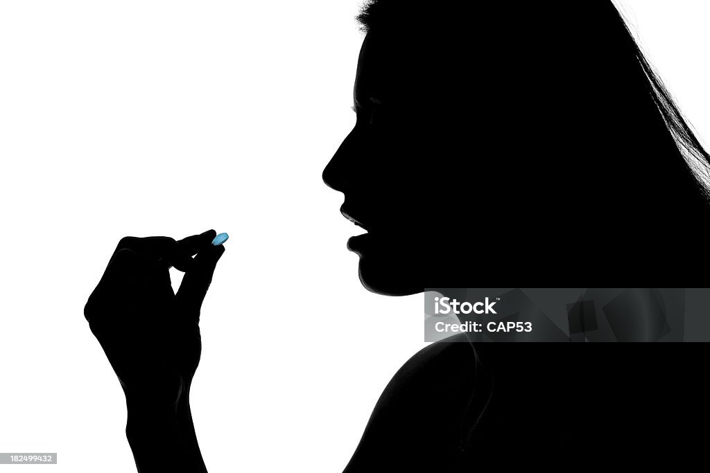 Woman Taking A Pill "Profil of a beautiful woman taking a pill.This photo has been produced in studio with these professionals : make-up artist, hair dresser and stylist. A professional retoucher gave it the final magic touch." Adult Stock Photo