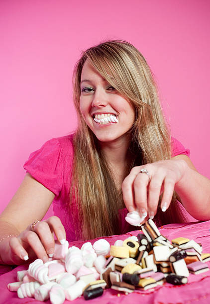 Young woman eating marshmallows