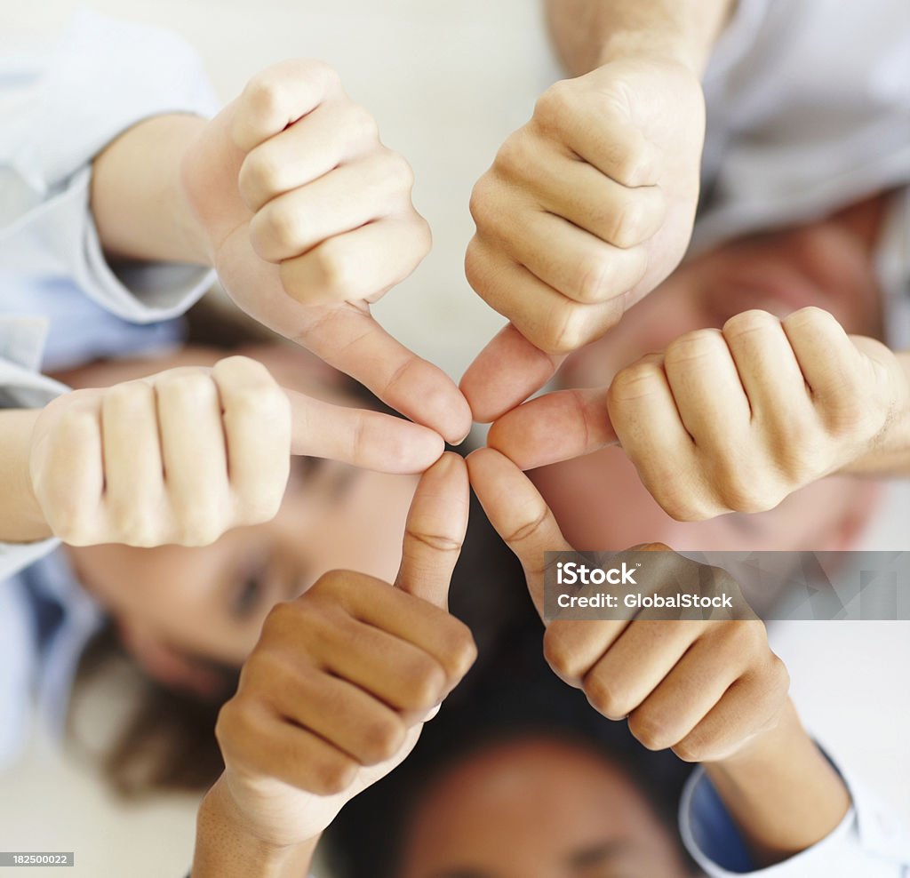 Three business colleagues showing thumbs up sign Three business colleagues showing thumbs up sign and gesturing unity Three People Stock Photo