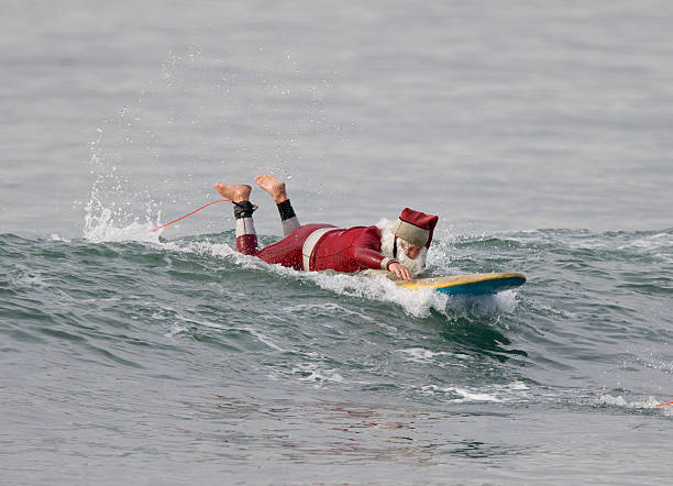 Santa Claus paddling into a wave stock photo