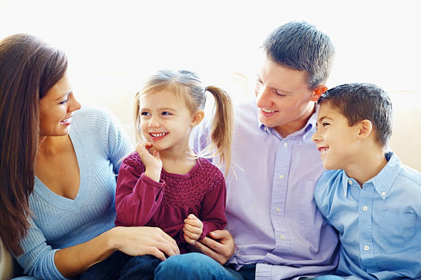 istock Family sitting together on a couch at home 182500607