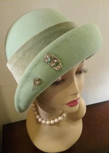 1920s style cloche hat with vintage pin on a mannequin display head