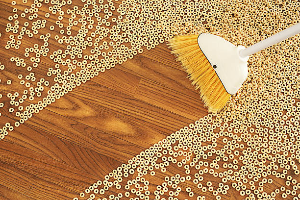 Broom Sweeping a Path Through Cereal Cleaning path made by a house broom through cereal spilled on a wooden floor.More cleaning paths: spilled cereal stock pictures, royalty-free photos & images