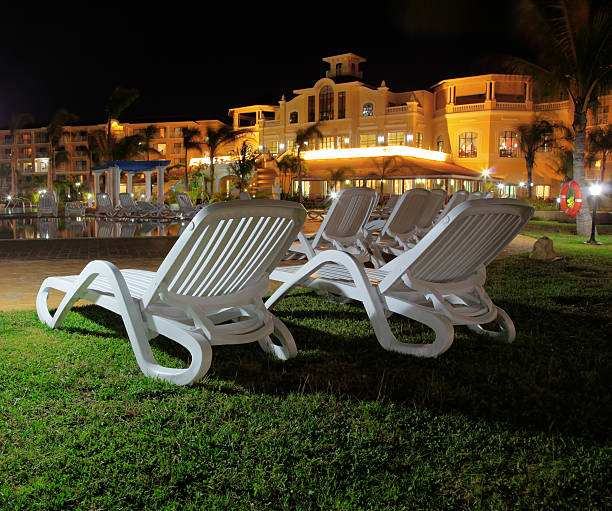 sedie a sdraio in un cortile dell'hotel di notte - motel swimming pool resort swimming pool tourist resort foto e immagini stock