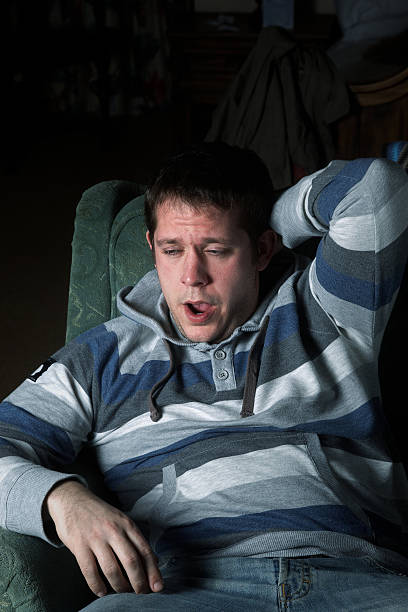 istock Young handsome couch potato yawning 182501738