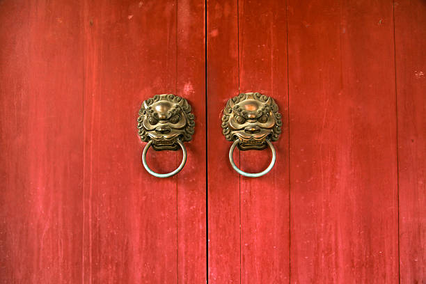 leone asiatico porta knockers su sfondo rosso - entrance door old ancient foto e immagini stock