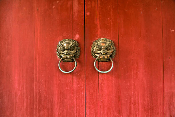 азиатские лев дверь knockers на красный фон - ancient antique painted image asia стоковые фото и изображения