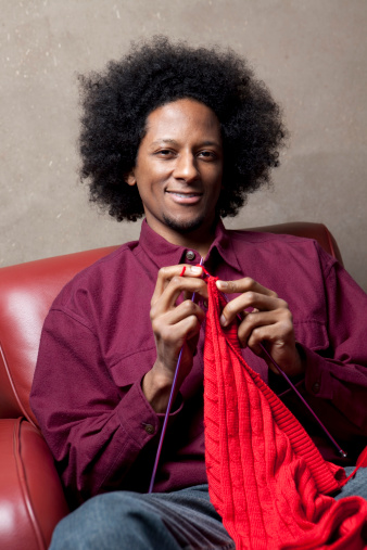 African American Man sitting in living room knitting a red sweaterPlease see similar images my portfolio: