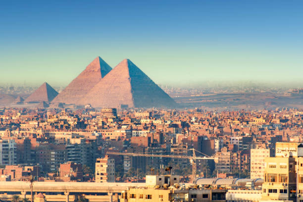 vista panorámica de la ciudad de el cairo con las grandes pirámides al fondo - town of egypt fotografías e imágenes de stock