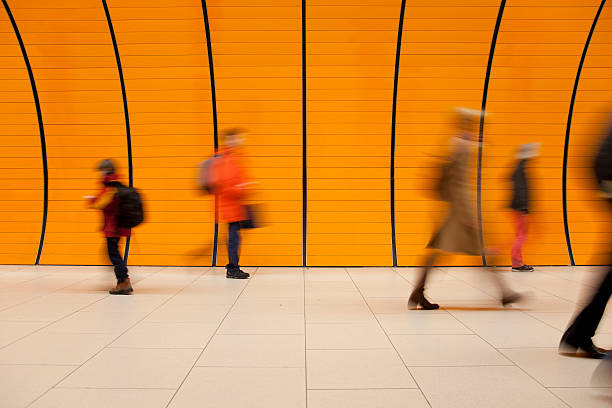 commuters against modern orange background stock photo