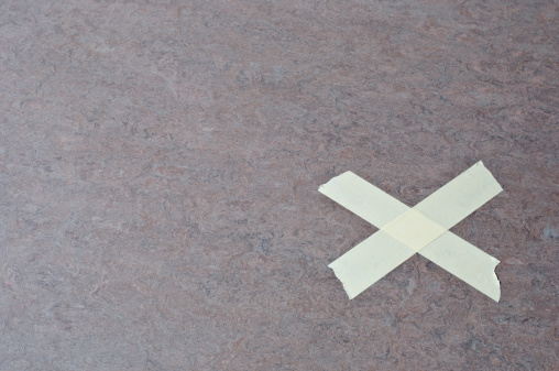 Floor with cross shaped tape marking the right spot.
