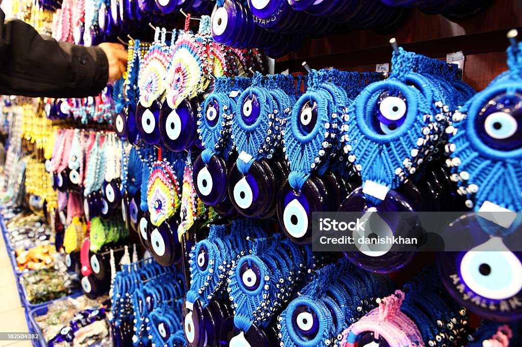 Nazar Boncuk In Turkey, wherever you look, you'll meet plenty of eyes looking at you. It is common in the Turkish culture to give a gift of a Blue Glass Nazar Boncugu (Nazar boncuk) or The Evil Eye Bead as it is more widely known.  People hang a small evil eye amulet from the rear view mirror of their car, keep several small evil eye beads or evil eye charms on hand to give to guests, hang an evil eye near their door in the home or office. Glass evil eyes are worn, in the form of jewelry; evil eye bracelet, evil eye necklace, evil eye anklet, gold or silver evil eye charms and evil eye pendant, evil eye earring - ring and blue evil eye talisman. Anklet Stock Photo