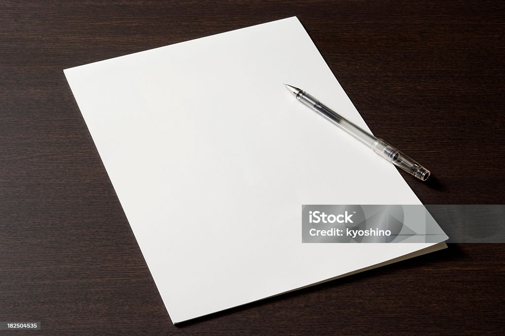 Blank document with pen on wooden desk Close-up shot of blank document with pen on wooden desk. Desk Stock Photo
