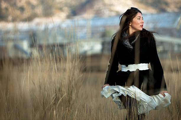 hermosa mujer corriendo por un campo de tall grass - searching fashion butte women fotografías e imágenes de stock