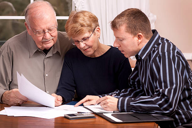 istock Old couple getting financial advice from young man 182504666