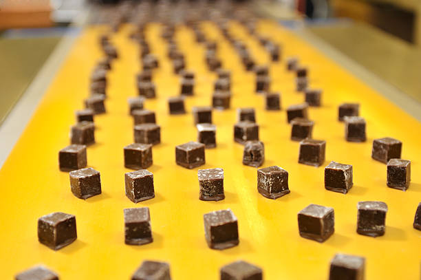 Caramels uma correia transportadora - fotografia de stock