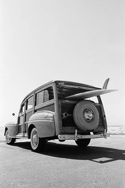 old woodie voiture familiale avec planche de surf - vague déferlante photos photos et images de collection