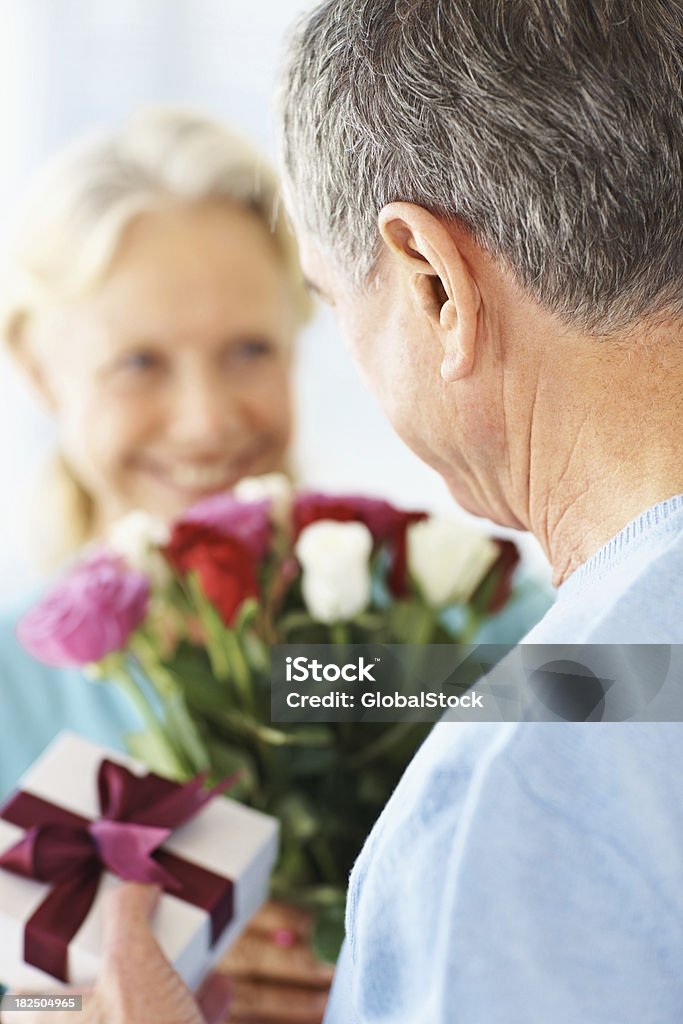 늙음 커플입니다 교환 꽃과 선물 고객의 기념일 - 로열티 프리 2명 스톡 사진