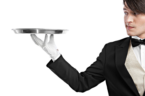Waiter looking at an empty aluminum (slightly dented and tarnished) tray with a contemptuous facial (mouth) expression.