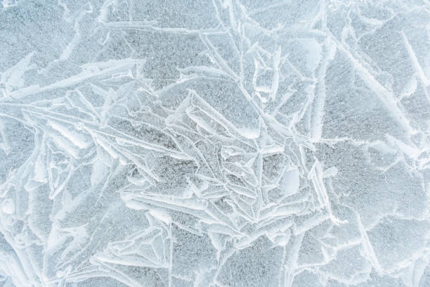 istock Background frozen water with fancy patterns. Ice texture. Cracks and bubbles inside frozen water. 1825051935