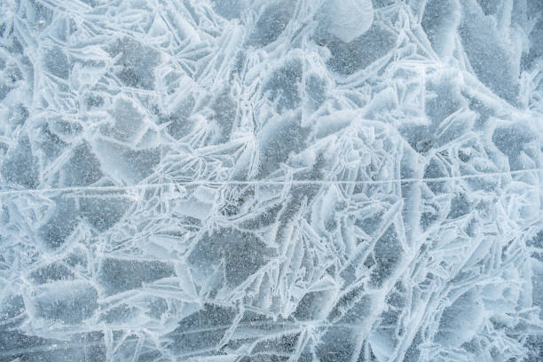 istock Background frozen water with fancy patterns. Ice texture. Cracks and bubbles inside frozen water. 1825052563