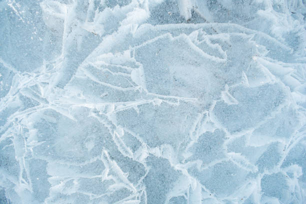 istock Background frozen water with fancy patterns. Ice texture. Cracks and bubbles inside frozen water. 1825053684