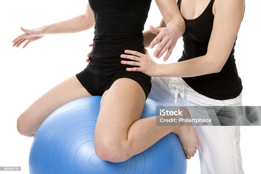 physical therapy Physical therapy. A female physiotherapist is assisting a young woman in therapeutic exercises. Exercises with swiss ball. Rehabilitation. Studio shot. High key. Isolated on white background. XXXL (Canon Eos 1Ds Mark III) Adult Stock Photo
