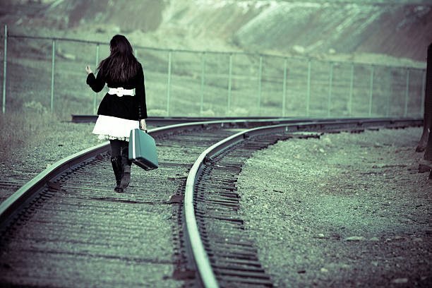 mujer con maleta caminar por tren pistas - searching fashion butte women fotografías e imágenes de stock