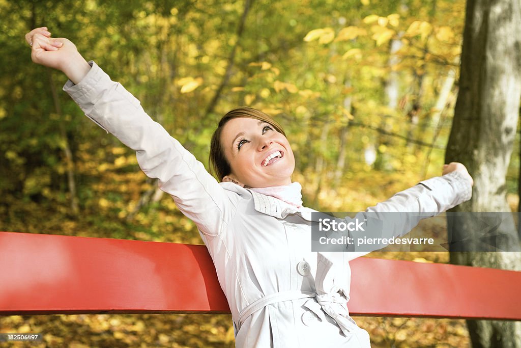 Donna felice e sorridente a raggiungere l'autunno - Foto stock royalty-free di Abiti pesanti