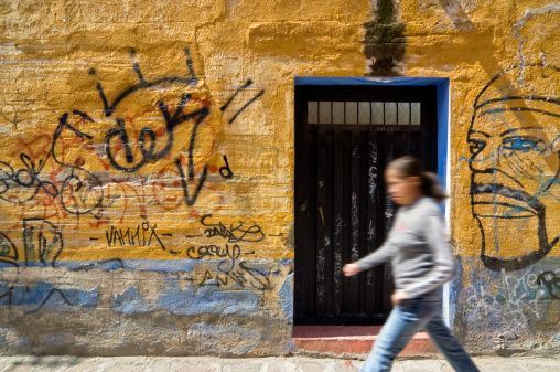 A woman walking past a doorway in a Mexican town.