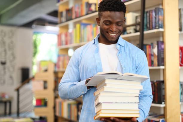 istock Happy young student in a library, surrounded by books, eager to gain knowledge. 1825067346