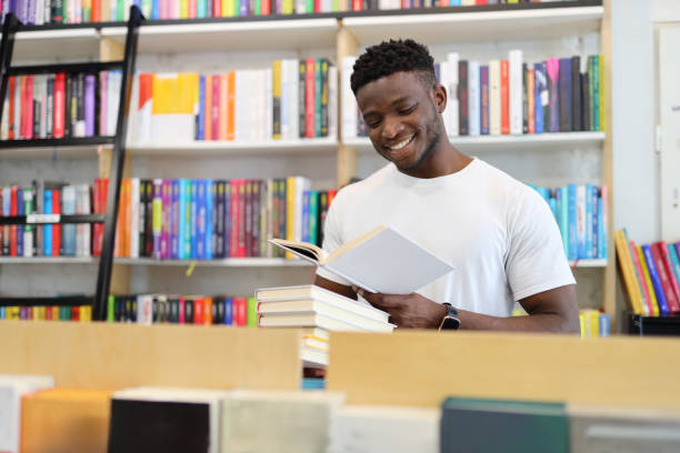 istock Joyful student in a university library, surrounded by books, showcasing intelligence and a love for learning. 1825067946