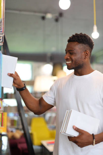istock Serious African student in a university library, making choices amid books, showcasing academic dedication. 1825067953