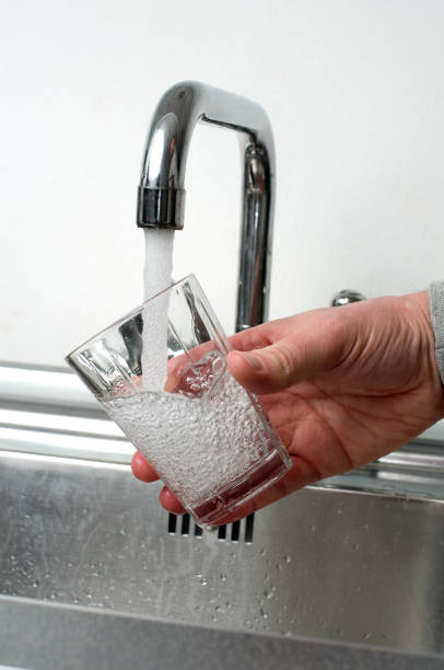 istock Glass is filled with fresh water from a faucet 182506977
