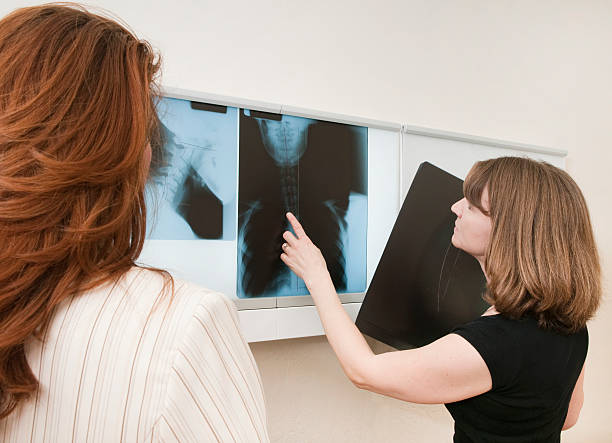 istock Reviewing X-Rays With Patient - Chiropractor Series 182507011