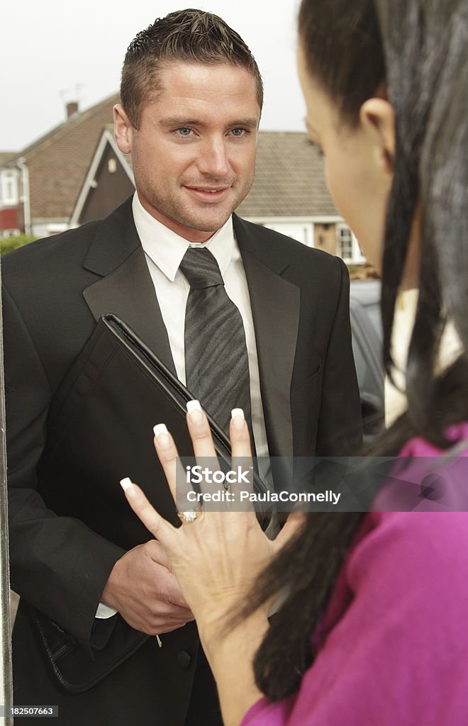 Woman Saying No to  Salesman A woman raises her hand to turn away a door to door salesman. Adult Stock Photo