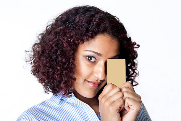 istock young woman peeking behind a credit card 182508074